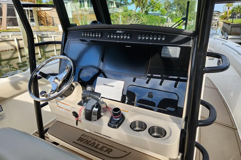 Slide: The Image of 2022 Boston Whaler 330 Outrage helm with modern controls and navigation displays. - 10