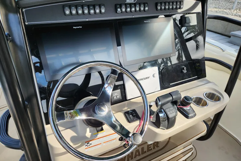 Slide: The Image of Control panel of a 2022 Boston Whaler 330 Outrage with steering wheel and digital displays. - 11