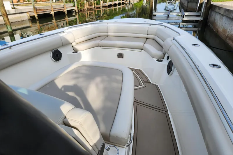 Slide: The Image of 2022 Boston Whaler 330 Outrage boat interior with cushioned seating and speakers. - 17