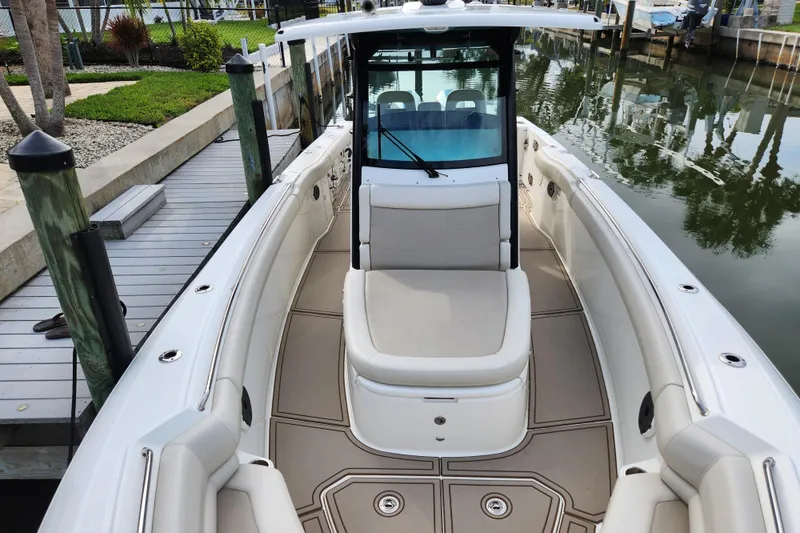 Slide: The Image of 2022 Boston Whaler 330 Outrage boat interior, docked by a serene waterfront. - 23