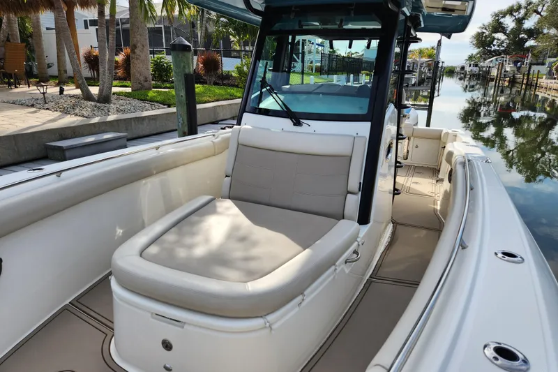 Slide: The Image of 2022 Boston Whaler 330 Outrage boat interior with seating, docked by a canal. - 25