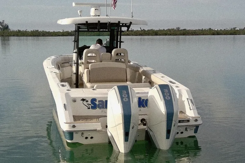 Slide: The Image of 2022 Boston Whaler 330 Outrage boat on calm water, rear view with dual engines. - 3