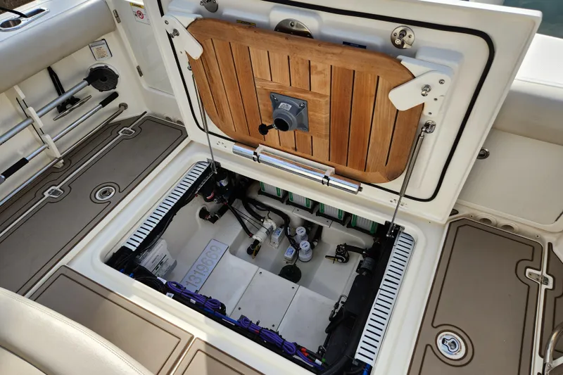 Slide: The Image of 2022 Boston Whaler 330 Outrage boat storage compartment with open hatch and visible equipment. - 35