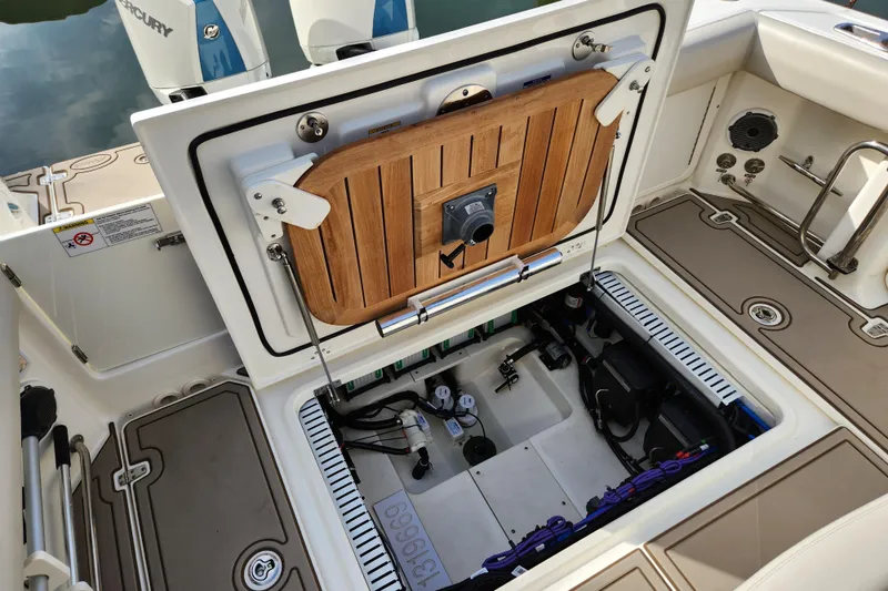 Slide: The Image of 2022 Boston Whaler 330 Outrage boat showing open hatch with engine components. - 36