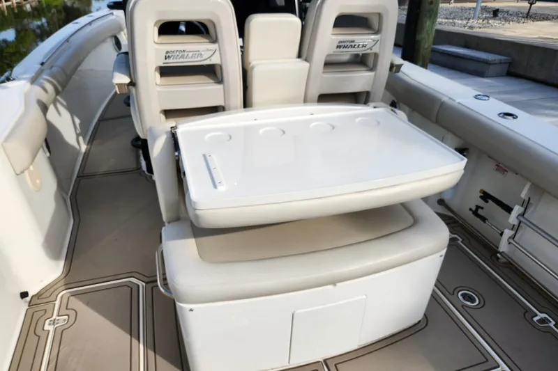 Slide: The Image of 2022 Boston Whaler 330 Outrage boat interior with seating and storage features. - 38