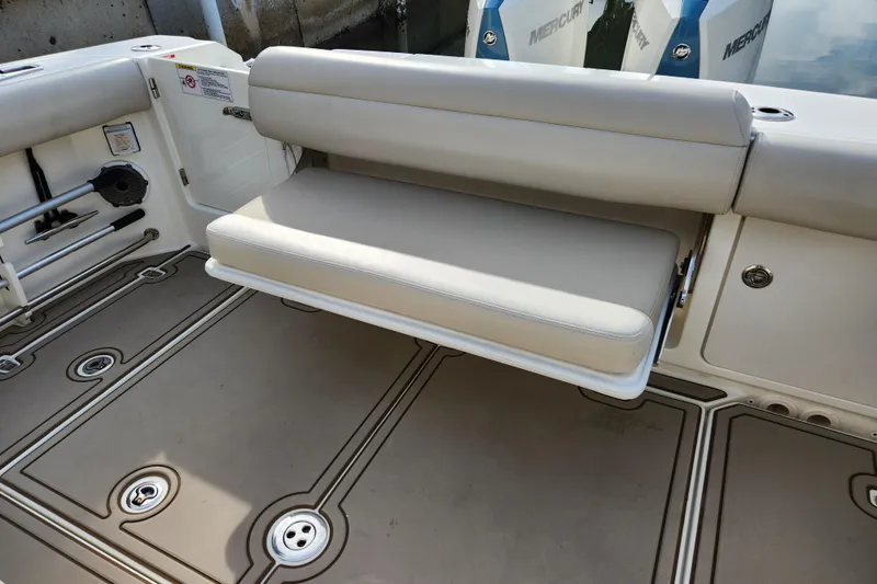 Slide: The Image of 2022 Boston Whaler 330 Outrage boat interior with foldable seating and Mercury engines. - 40