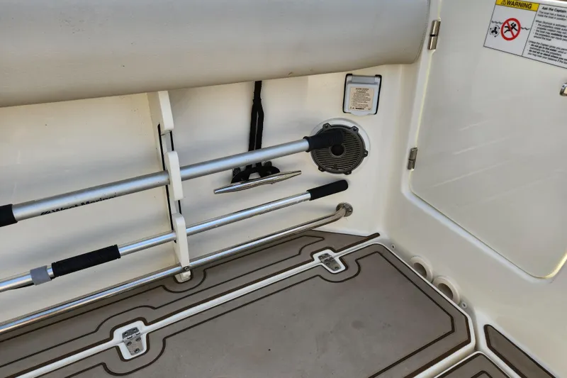 Slide: The Image of 2022 Boston Whaler 330 Outrage interior with rod holders and storage compartment. - 45