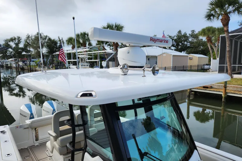 Slide: The Image of 2022 Boston Whaler 330 Outrage boat with Raymarine radar, docked near palm trees. - 53