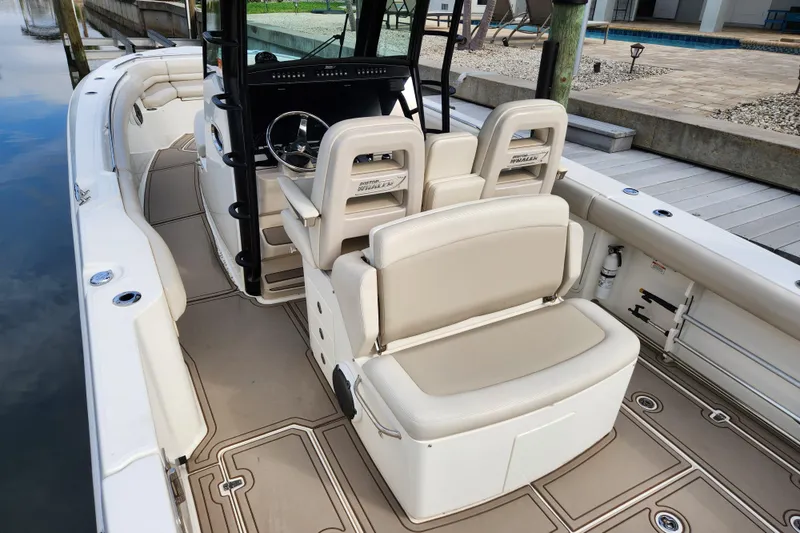 Slide: The Image of 2022 Boston Whaler 330 Outrage boat interior with beige seating and modern helm. - 6
