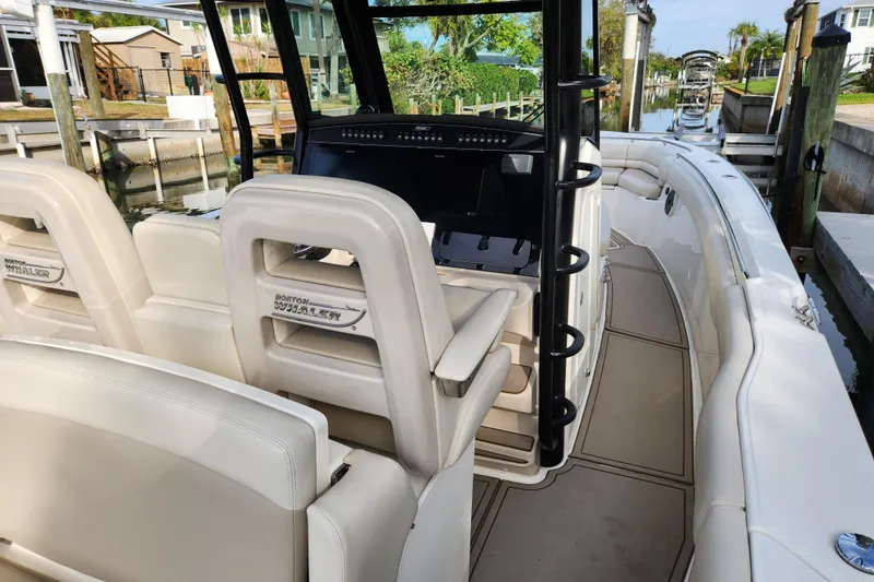 Slide: The Image of 2022 Boston Whaler 330 Outrage boat interior with luxurious seating and modern dashboard. - 9