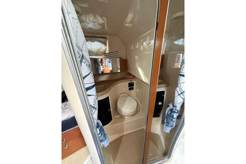 Slide: The Image of 2005 Wellcraft 290 Coastal boat interior with compact bathroom and shower area. - 11