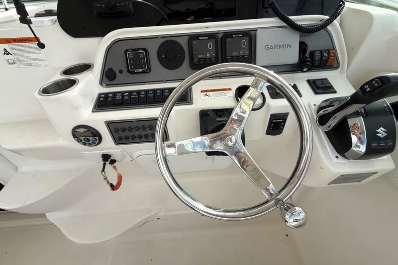 Slide: The Image of 2005 Wellcraft 290 Coastal helm with steering wheel, controls, and Garmin navigation system. - 13