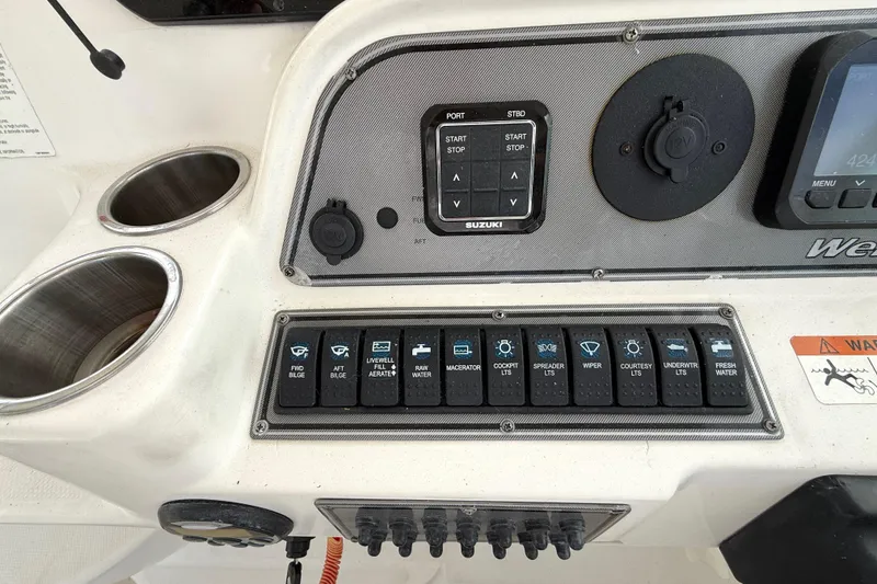 Slide: The Image of Control panel of a 2005 Wellcraft 290 Coastal boat with various switches and cup holders. - 14
