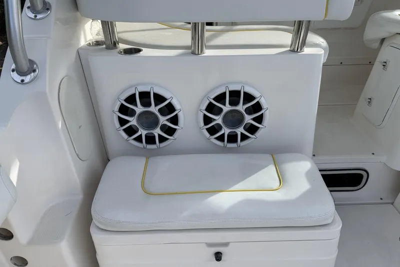 Slide: The Image of 2005 Wellcraft 290 Coastal boat interior with dual speakers and cushioned seating. - 17