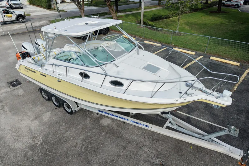 Slide: The Image of 2005 Wellcraft 290 Coastal boat on trailer, parked in a lot. - 2