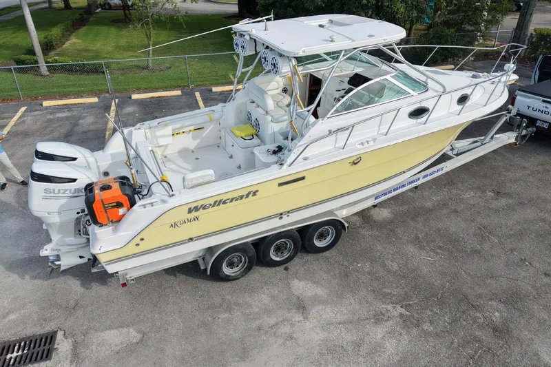 Slide: The Image of 2005 Wellcraft 290 Coastal boat on trailer, featuring dual Suzuki engines. - 3