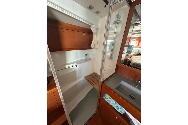 Slide: The Image of 2014 Beneteau Oceanis 48 yacht bathroom with shower, sink, and wooden cabinetry. - 11
