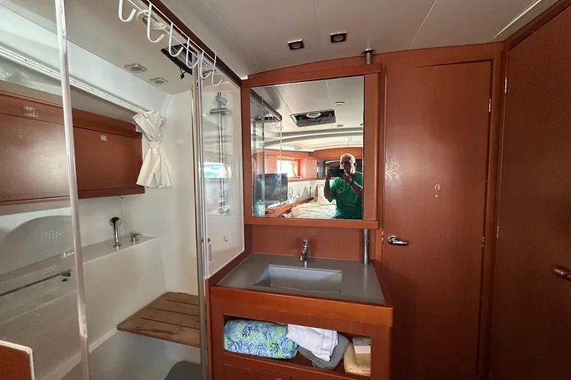 Slide: The Image of Interior of 2014 Beneteau Oceanis 48 yacht bathroom with sink, mirror, and shower. - 13