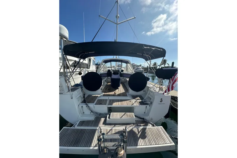 Slide: The Image of 2014 Beneteau Oceanis 48 yacht with spacious deck and canopy, docked at marina. - 2