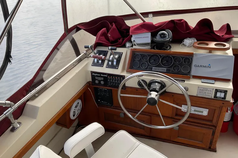 Slide: The Image of 1982 Bayliner 4050 Bodega boat helm with steering wheel, gauges, and Garmin navigation system. - 13
