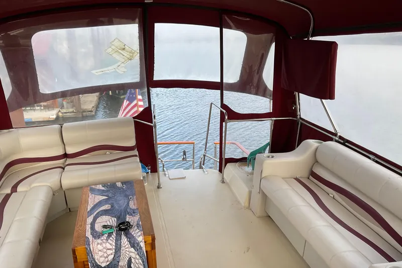 Slide: The Image of 1982 Bayliner 4050 Bodega boat interior with seating, table, and water view. - 15