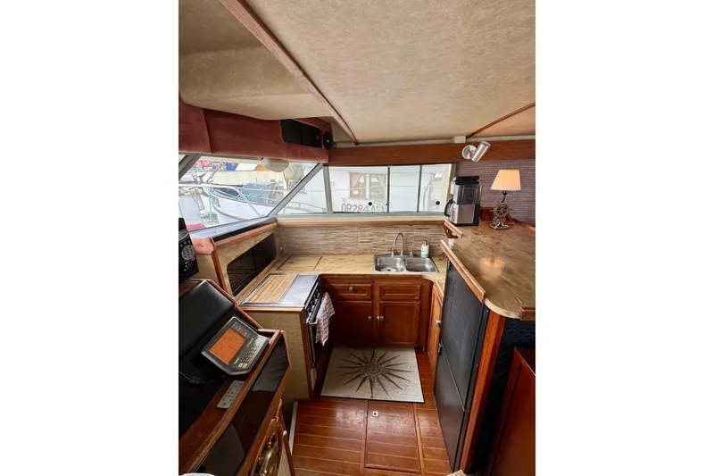 Slide: The Image of 1982 Bayliner 4050 Bodega yacht interior with kitchen, sink, and wooden cabinetry. - 2