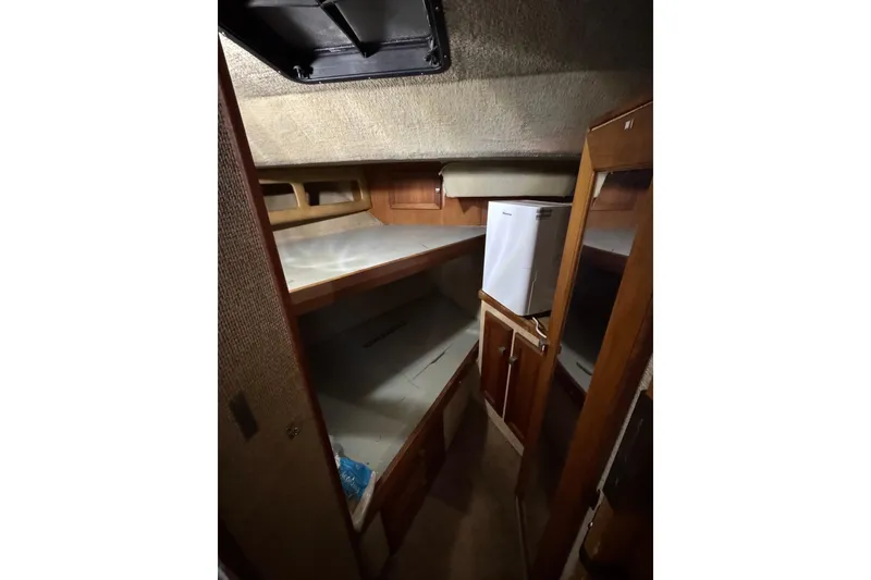 Slide: The Image of Interior cabin of 1982 Bayliner 4050 Bodega with compact fridge and wooden cabinetry. - 25
