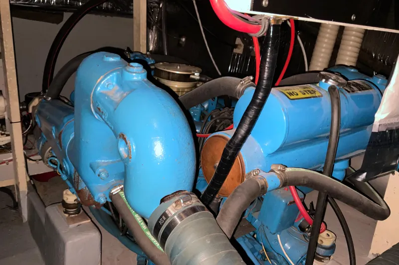 Slide: The Image of Engine room of 1982 Bayliner 4050 Bodega with blue marine engines and hoses. - 29