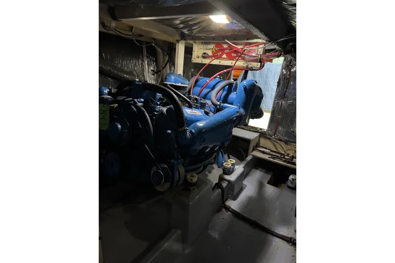 Slide: The Image of Engine room of 1982 Bayliner 4050 Bodega, featuring a blue marine engine. - 33