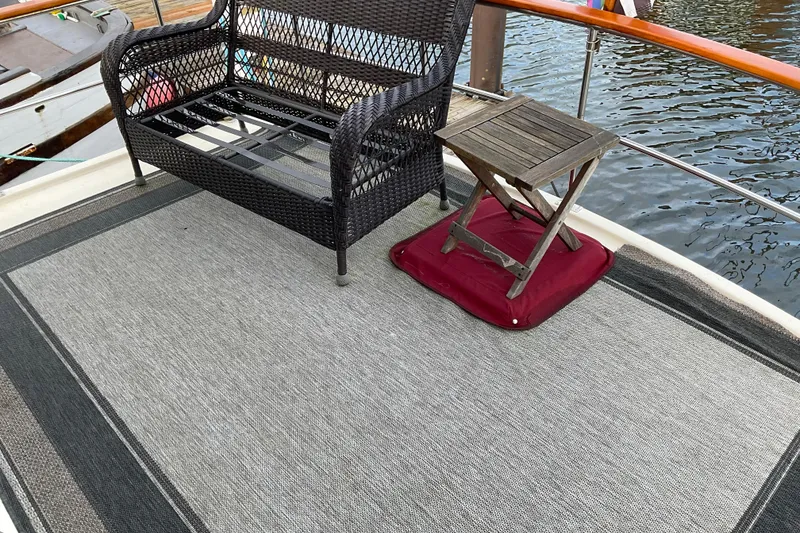 Slide: The Image of Deck of 1982 Bayliner 4050 Bodega with wicker bench and wooden table. - 6