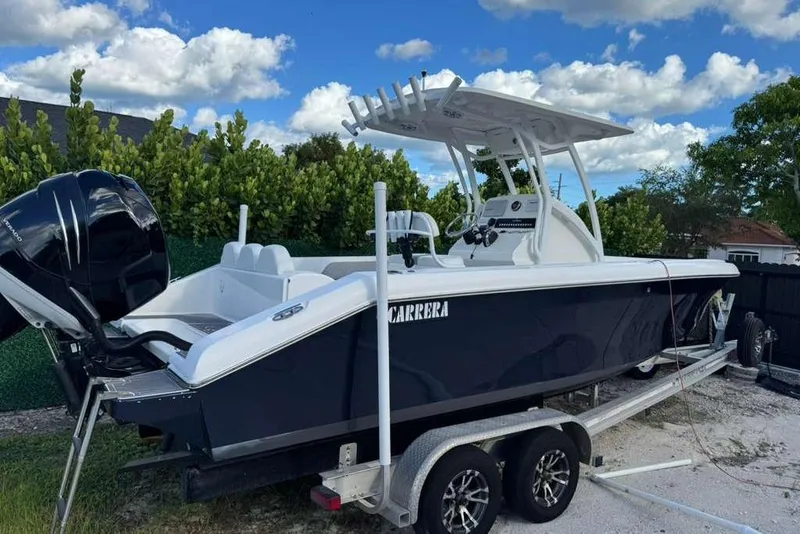 Slide: The Image of 2018 Carrera Powerboats 23 on trailer, sleek design, black hull, outdoor setting. - 0