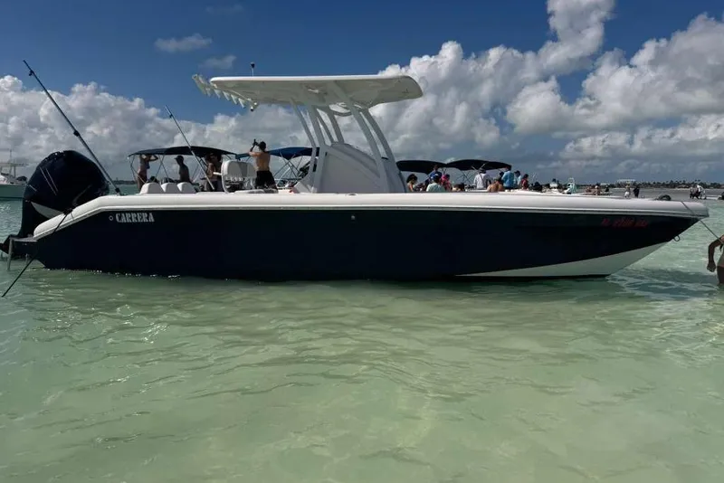 Slide: The Image of 2018 Carrera Powerboats 23 in shallow water, with people onboard under a clear sky. - 1
