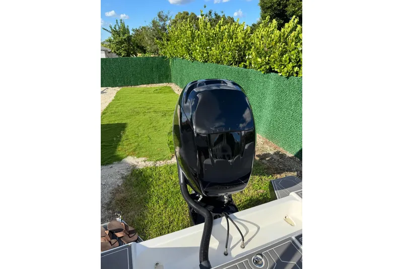 Slide: The Image of 2018 Carrera Powerboats 23 with sleek black outboard motor in a grassy yard. - 13