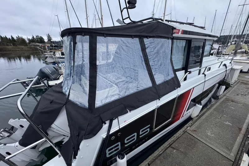 Slide: The Image of 2025 Jeanneau NC 895 Sport Series 2 docked at marina, featuring enclosed cockpit. - 2