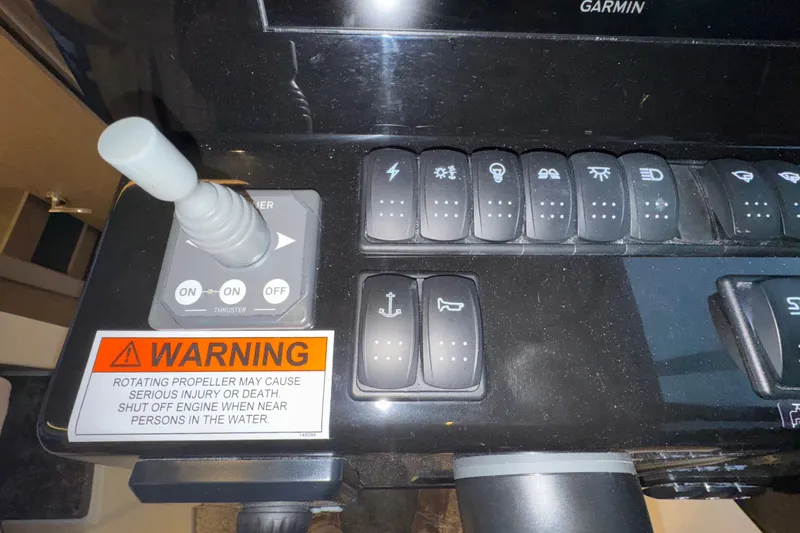 Slide: The Image of Control panel of 2025 Jeanneau NC 895 Sport Series 2 with warning label and switches. - 24