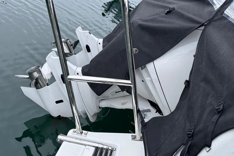 Slide: The Image of 2025 Jeanneau NC 895 Sport Series 2 boat engines partially covered, docked in water. - 3