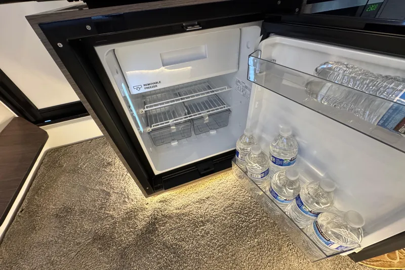 Slide: The Image of Compact fridge in 2025 Jeanneau NC 895 Sport Series 2, stocked with water bottles. - 32