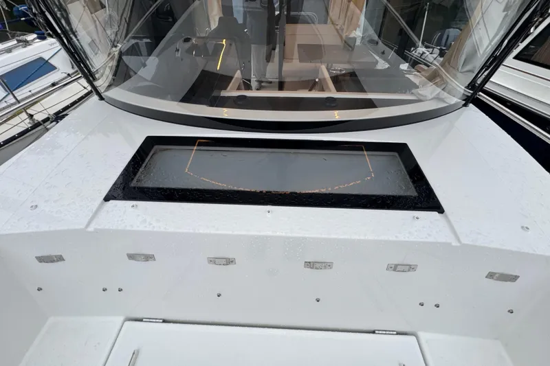 Slide: The Image of 2025 Jeanneau NC 895 Sport Series 2 boat deck with windshield and storage compartment. - 58