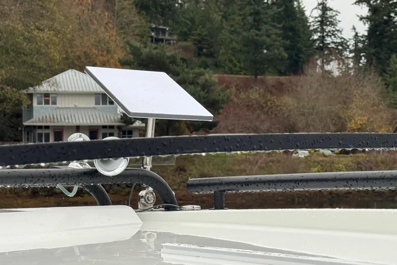 Slide: The Image of 2025 Jeanneau NC 895 Sport Series 2 with satellite dish, forested background. - 61