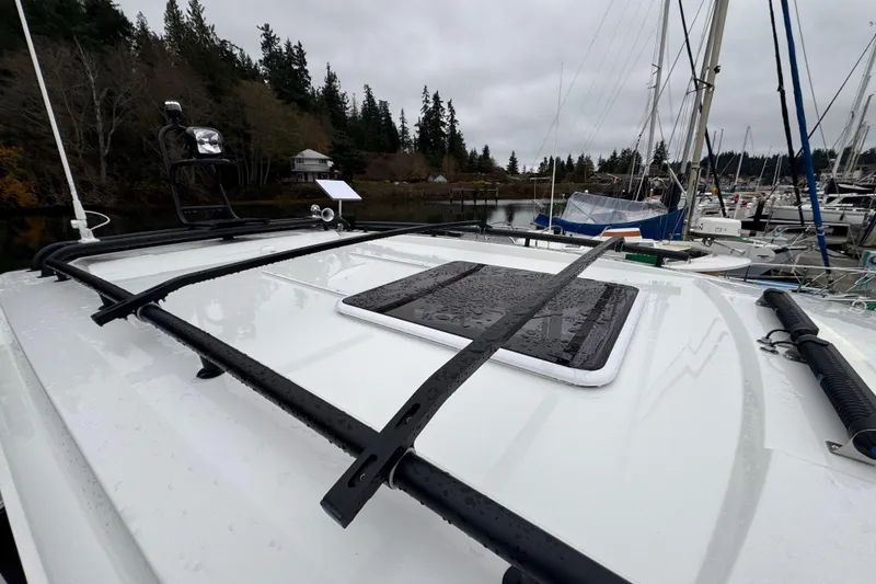 Slide: The Image of 2025 Jeanneau NC 895 Sport Series 2 boat roof with railing and hatch, docked in marina. - 62
