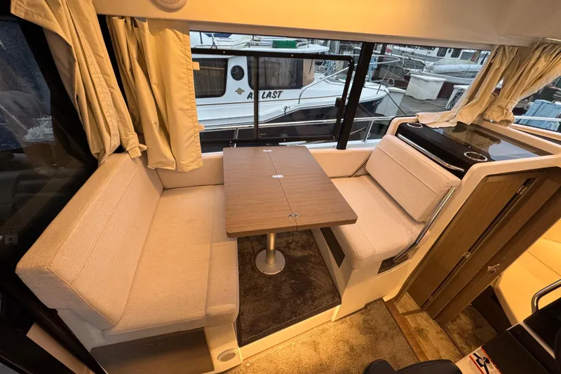 Slide: The Image of Interior of 2025 Jeanneau NC 895 Sport Series 2, featuring cozy seating and dining area. - 7