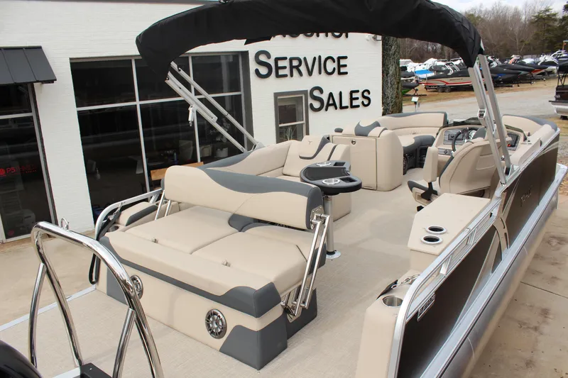 Slide: The Image of 2026 Tahoe Pontoon LTZ boat with beige seating at a sales service location. - 7