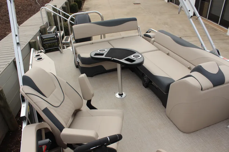 Slide: The Image of 2026 Tahoe Pontoon LTZ interior with beige seating and table, docked at marina. - 8