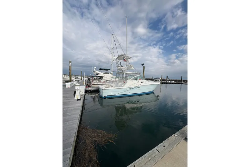 Slide: The Image of 2007 Rampage 38 Express boat docked at marina under cloudy sky. - 35