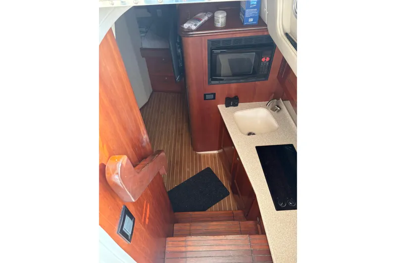 Slide: The Image of Interior of 2007 Rampage 38 Express yacht with kitchenette, microwave, and wooden flooring. - 38