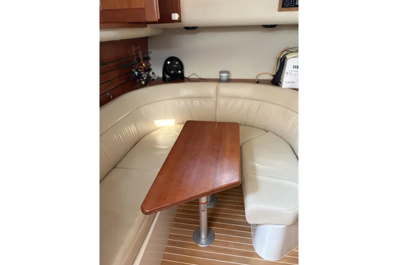 Slide: The Image of Interior of 2007 Rampage 38 Express boat with wooden table and beige seating. - 39