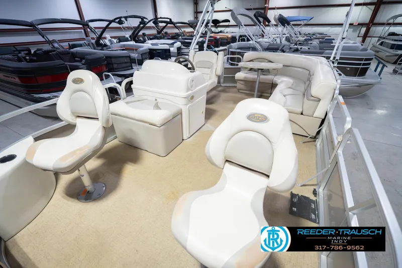 Slide: The Image of 2009 Sylvan 818 Mirage Fish boat interior with seating and steering console in showroom. - 12