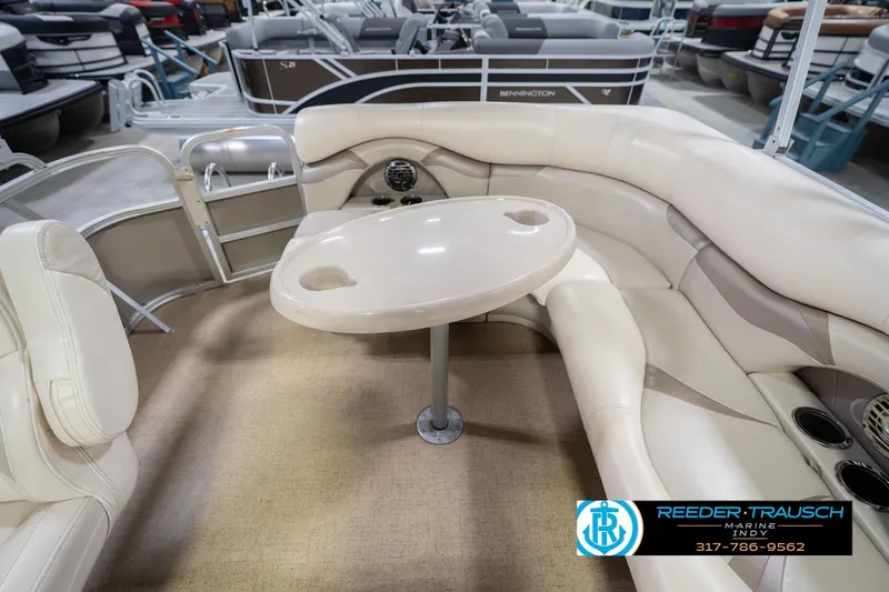 Slide: The Image of 2009 Sylvan 818 Mirage Fish boat interior with beige seating and table. - 18