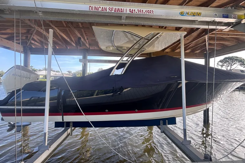 Slide: The Image of 2023 Chris-Craft Calypso 24 boat covered and docked on a lift. - 19
