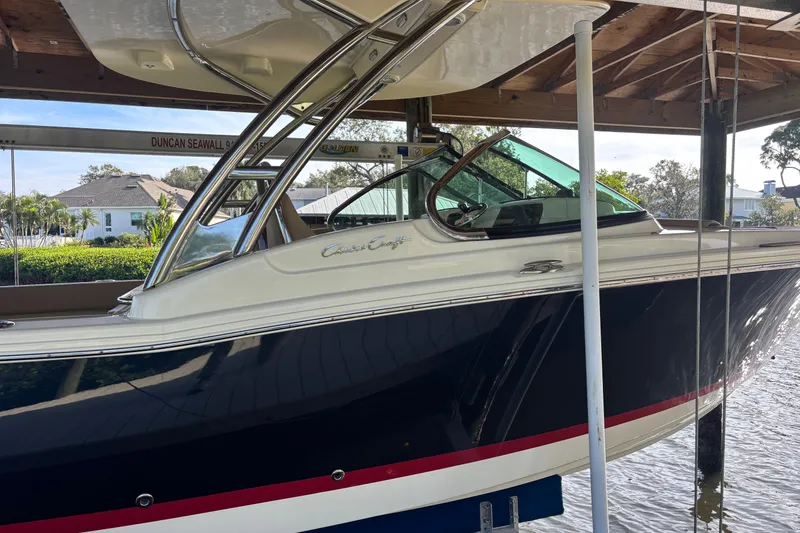 Slide: The Image of 2023 Chris-Craft Calypso 24 boat docked under a wooden shelter. - 21